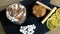 Cocoa with marshmallow in rock glass on a wood black tray with cake and lemon. Close-up top view.