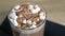 Cocoa with marshmallow in rock glass on a wood black tray. Close-up view.