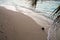 Coconut on a beach beneath a palm tree on a tropical island in the Maldives, with footprints in sand