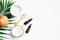 Coconut beauty products with tropical palm leaf on white background. Flat lay, top view, copy space. Skin care, aromatherapy