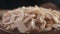 Coconut chips are falling down to wooden bowl close-up