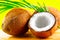 Coconut with coconuts green palm tree leaf on yellow background. Beauty treatments. Coco nut closeup. Healthy Food, skin care