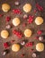 Coconut cookies with sprigs of red currant and peeled chestnuts sprinkled with coconut flakes on a wooden dark brown background
