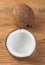 Coconut and cracked half fruit over wooden table