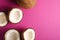 Coconut fruits on pink purple vibrant plain background, top view copy space