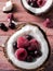 Coconut halves with Frozen Berries on a dark wooden background.