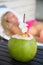 Coconut juice drink with woman on lounger near a swimming pool