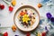 coconut milk porridge with a colorful berry medley on top
