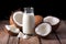 coconut milk and whole coconuts arranged on wood table