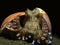 Coconut octopus stayed between shells on black sand bottom.