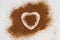 Coconut palm sugar is chaotically scattered on a surface with a halo in the shape of a heart