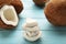 Coconut and pieces of coconut on a blue wooden background. Halves and whole coconuts. Top view