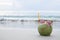 Coconut refreshment exotic juice with straw on the beach