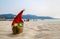 Coconut in a Santa Christmas hat in sand on a tropical beach - Holiday tropic summer concept.