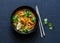 Coconut shrimp laksa soup on a dark background, top view.