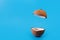 Coconut split in half and flying on isolated blue background. Coconut levitating. podium concept.