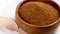 Coconut sugar made from the kithul palm (Caryota urens) in wooden bowl with bamboo teaspoon.