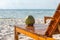 Coconut tropical drink on chair on the white sand beach