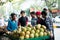 Coconut vendor and cart surrounded by people eager to drink