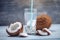 Coconut water in the composition with white flesh on blue wooden background. Organic product widely used in cosmetology