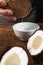 Coconut water pouring into white bowl close up