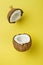 Coconut on yellow colored background, minimal flat lay style.