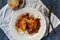 Cod with red peppers, tomato and onion on a white plate