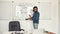 Code academy online. Young serious bearded male teacher wearing glasses pointing at whiteboard and teaching HTML CSS