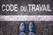 Code du travail meaning labor code in French written on an asphalt road background with legs