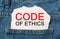 Code of Ethics on torn paper background on jeans business and finance concept