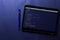 Coding and programming for web development and web design concept on tablet screen with blue pen on blue pattern