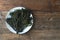 Codium fragile. Green algae in a ceramic dish on a wooden background