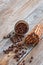 Coffe beans in a bowl made of coconut shell and heap of cinnamon spices.