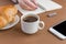 Coffe break with croissant and espress. Woman writing on notebook . Freelancer at work