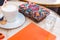 Coffe cappuccino, orange notebook, glass of water and colorful accessories