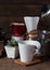 Coffe drip set with,roasted beans,kettle,grinder,white cup and flower pot on wood table and background