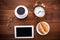 Coffee, alarm clock, glasses, digital tablet and croissants