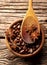 Coffee, anise in brown bowl on wooden background.