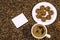 Coffee bean background with cup of fresh hot coffee and plate full of cookies