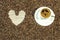 Coffee bean background with heart and cup of fresh hot coffee