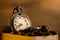 Coffee bean and pocket watch in manual grinder on table.