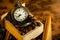 Coffee bean and pocket watch in manual grinder on table.