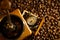 Coffee bean and pocket watch the tray of manual grinder on table.