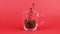 Coffee bean quickly fly, intersperse glass cup, red background. Overwork concept