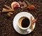 Coffee beans background with cofee cup, cinnamon, and chocolate