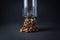 Coffee beans on a black background. Coffee beans in a small pile, glass on top