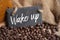 Coffee beans with black chalkboard or slate plate with message Wake up