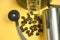 Coffee beans on bucket and grinder yellow background