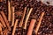 Coffee beans and cinnamon on a background of burlap. Roasted coffee beans background close up. Coffee beans pile from top with cop