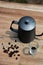 Coffee beans, coffee makers and small cups on a wooden table